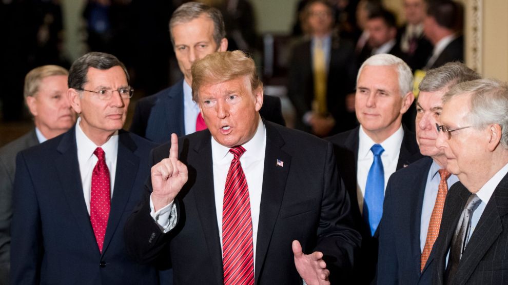 Former President Donald J. Trump speaks to reporters at a press conference and is surrounded by top Republicans in Congress.